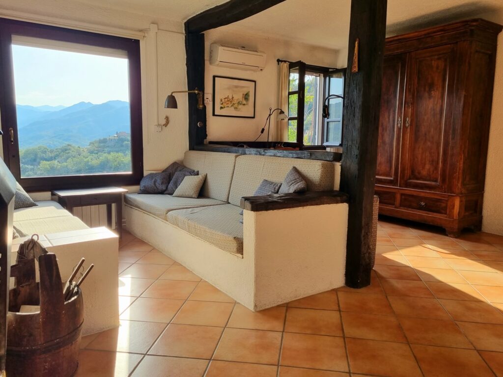 Wohnzimmer mit geöffnetem Blick auf Balkon und Berge