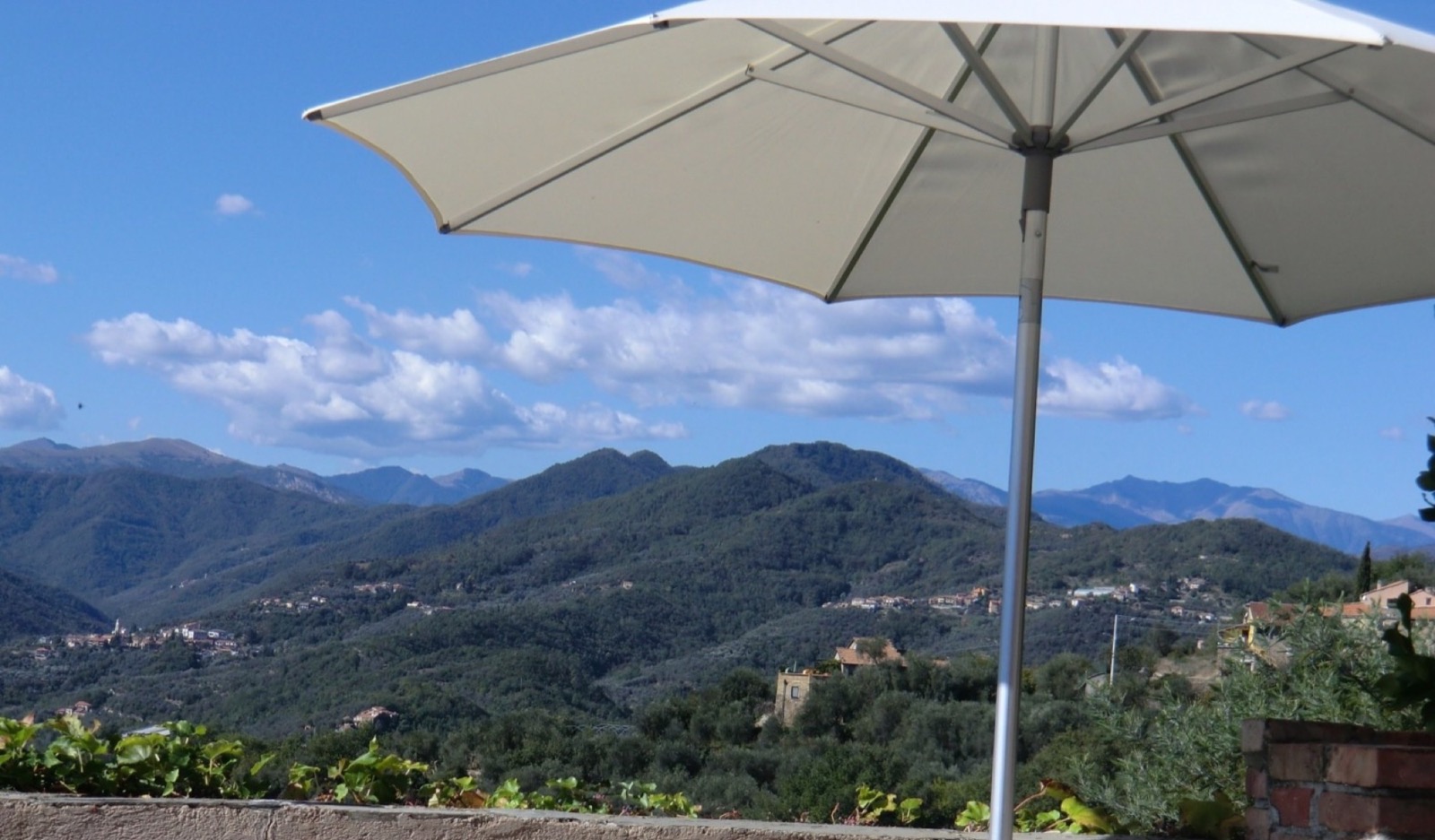Sonnenschirm und Blick über die ligurischen Berge